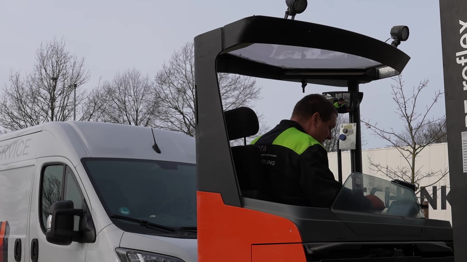 Servicetechniker Martin fährt einen Kommissionierer neben dem Servicefahrzeug im Freien